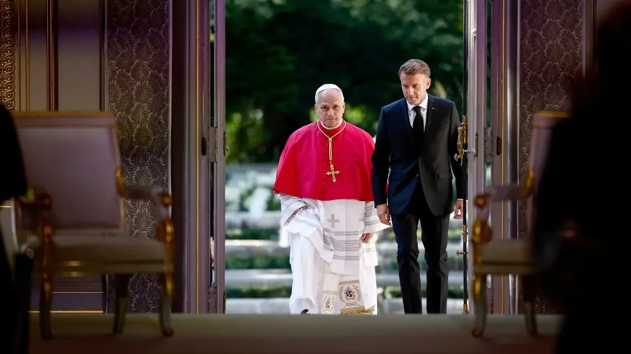 El papa León XIV saludando a su llegada a la escalerilla del avión en el aeropuerto de Orly, en París.