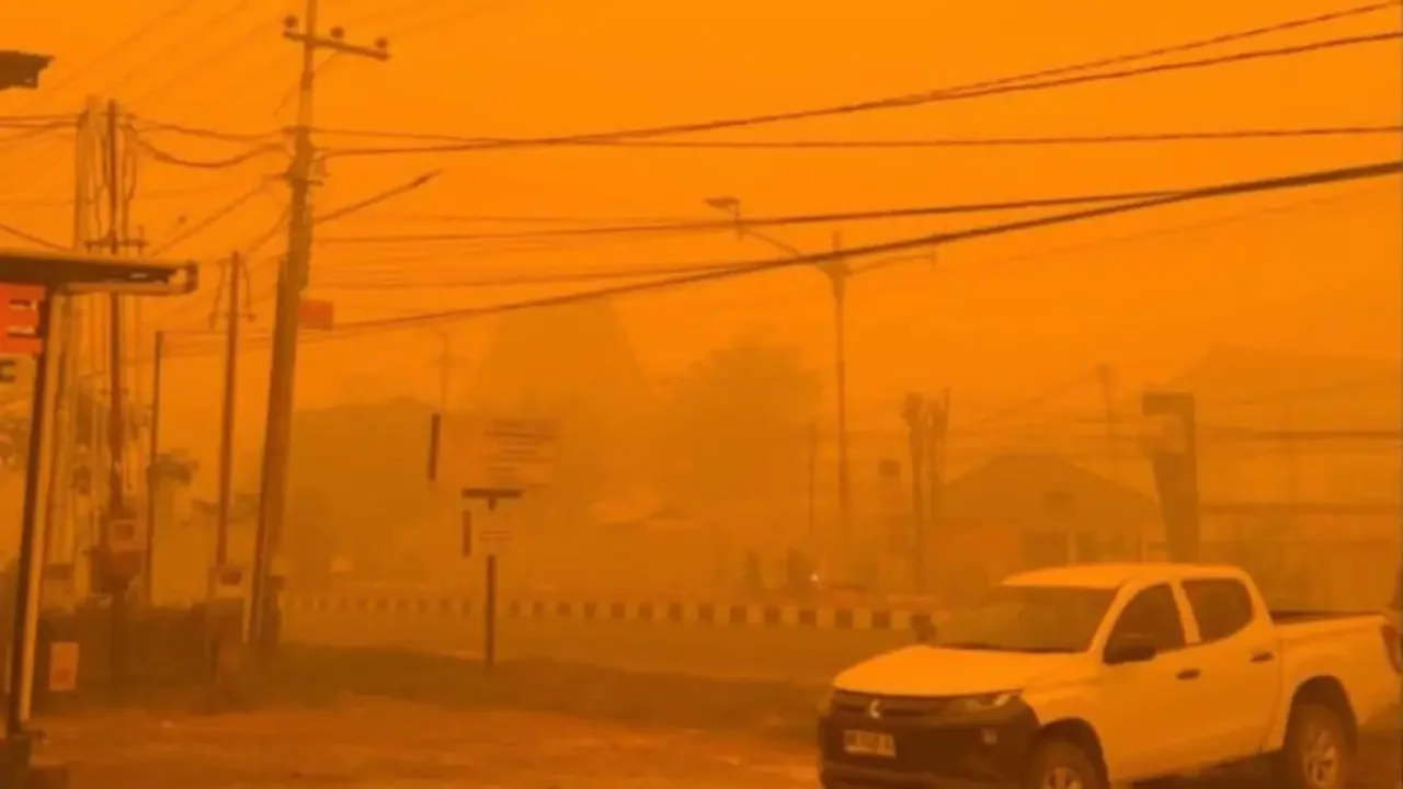 Paisaje en Indonesia con un cielo teñido de tonos naranjas y sepia a causa del humo de incendios forestales.